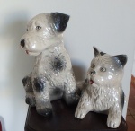 Par de escultura em porcelana de animais domésticos sendo um gato e um cachorro. Med. 23 e 15cm