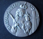 Medalha de metal banhado a prata com imágem de monarca segurando criança em relevo ao centro. Uma face.,nas bordas a inscrição B.M.V .AMO. Nteserr ato - diam. 60 mm