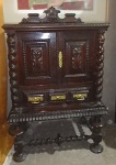 Bar colonial em madeira torneada, puxadores em metal dourado, uma gaveta e duas portas, parte interna espelhada. Med. 136 x 72 x 50 cm.