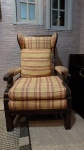 Poltrona / Bergere, em madeira nobre entalhada, pernas retas, assento e encosto estofados. Med.: 107 x 58 x 63 cm.