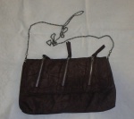 Bolsa feminina em couro marrom,parte interna com bolso, decorada com fecho-éclair e alça em  corrente prateada, em bom estado.