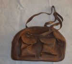 Bolsa feminina em couro marrom com alça em couro, parte da frente 2 porta objetos.