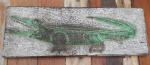 Placa de  parede  em madeira entalhada com figura de jacaré. med.: 17 x49 cm