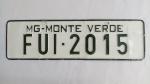 Placa Decorativa Monte Verde/MG "FUI-2015" Festival de Inverno; alto relevo, em metal reportando formato placa de carro; aprox. 38 x 11cm, marcas do tempo