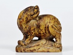 Escultura de pedra dura, miniatura, representada por cão de fó. Med. 3 cm x  4 cm x 2 cm de profundidade. Marcas do tempo. pequenas faltas. No estado.
