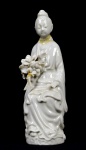 Bela escultura  de  porcelana dita "blanc de chine", representada por Kuan Yin segurando bouquet de flores.. Med. 16 cm x  6 cm x  5 cm de profundidade. Marcas do tempo. pequenas faltas com perdas de substância. pescoço colado. No estado.