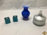 Lote composto de 2 castiçais em resina, vaso floreira em vidro leitoso azul e caixa em vidro fosco com interior dourado. Medindo o vaso 14,5cm de altura.