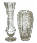 Dois vasos em cristal europeu incolor, à saber: a) Vaso em formato piriforme profusamente lapidado. 20 cm. b) Vaso em cristal moldado em formato cilíndrico com corpo afunilado na parte média, rematado com caneluras verticais incisas e detalhes lapidados. 25 cm (Dois ínfimos bicados na borda, podendo ser lapidado).