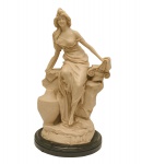 Escultura em resina, representando figura feminina debruçada sobre rochedo. Século XX. 40 cm.