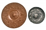 Dois medalhões em cobre batido, sendo o primeiro ornamentado com motivos de caça, e o seguinte com atributos do `Deus Sol` Asteca. 31 cm e 19 cm.