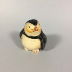 filhote de pinguim de coleção em cerâmica vitrificada tendo 7 cm de altura por 6 de lado. Assinado "22" na base.