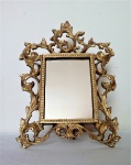 Espelho de mesa em bronze maciço  e polido rematado por arabescos. Exemplar antigo e de brilho intenso. Dimensões: 25 cm altura x 18 cm largura.