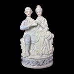 Estatueta em fina porcelana vitrificada representando casal nobre. Belíssimos detalhes. Dimensões: 20 cm altura.