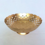Bowl em metal dourado, de origem Indiana, decorado com flor e arabescos em alto relevo. Borda ondulada e galeria com belíssimos vazados.  Pequeno furo no meio. Dimensões: 17 cm diâmetro x 7 cm altura.