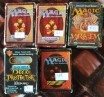 Cinco pacotes Magic the Gathering, estampas coloridas, quatro pacotes com sessenta e um pacote com quarenta e oito.