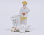 Floreira em porcelana alemã policromada, representando menino com cesto. Med.alt 13 x 5 x 8,5 cm.