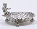 Saboneteira em prata portuguesa contraste Águia. Elegante formato em concha com figura de menino sentado e três pés em forma de golfinhos. Med. 5 x 9 x10 cm. Peso 129 gr.
