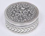 Caixa redonda em prata de lei, rico trabalho com flores em relevo na tampa e geométricos na lateral. Med. 3 x 8 cm. Peso 94 gr.