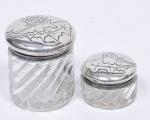 Dois recipientes de toilette em cristal Baccarat translúcido, com torcidos e tampa em prata francesa do séc. XIX. Decoração com flores e folhagens em baixo relevo ( pequena mossa ). Med. 9,5 x 9,5 cm de diâmetro e 4,5 x 7,5 cm de diâmetro.