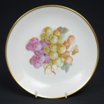BAVARIA - Lindo prato em porcelana Alemã, decorativo, decorado com cachos de uva e borda filetada à ouro. Selado na base. Med.: 19,5 cm.