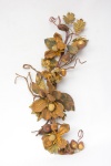 Elegante enfeite de mesa em meterial sintético representando " folhas e frutos" patinados a ouro velho. Med.: 70 cm.