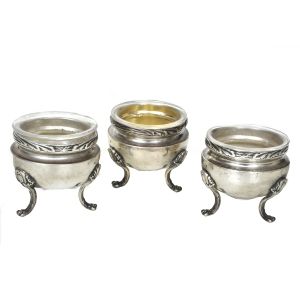 Conjunto de 3 saleiros em prata francesa repuxada e cinzelada com contraste `cabeça de mercúrio` 950 mls com recipientes em vidro. Med.: 4,8 x 5,2 cm.
