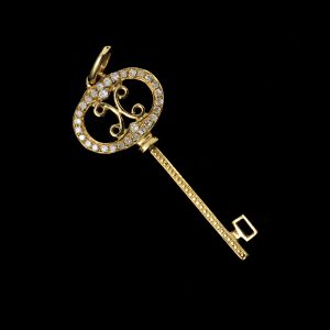 Pingente em ouro amarelo 18 kl `chave` cravejada com diamantes. Peso:  1g. Comprim: 3,5 cm