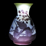 EMILE GALLÉ - Vaso em pasta de vidro acidada, com sobrecapa na cor violeta escuro, com relevo de grandes folhas, ramos flores, corpo balaustre, assinado em relevo . Altura: 23 cm