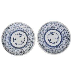 Par de pratos em porcelana japonesa decorada com rica pintura `azul e branco` de ramos e folhas, com espiral em baixo relevo ao centro. Marcado no fundo. Diâmetro: 22 cm.