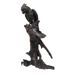 Escultura de papagaio em bronze japonês patinado em fina fundiçãos da anatomia e plumagem, pousado sobre grande tronco em madeira. Marcado na calda interna, período Meiji, (1867-1912), século XIX. Altura: 78 cm(escultura e tronco) ou 36 cm(altura da cacatua)