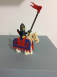 Lego figura medieval com cavalo, capacete, bandeira.