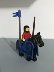 Lego figura medieval com cavalo, capacete, lança e bandeira.