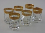 Seis copos em cristal com decoração em ouro. Altura 6,5  cm.