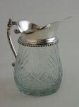 Jarra em cristal lapidado com borda e pegador em metal prateado.  Altura 16 cm , diâmetro 10 cm.