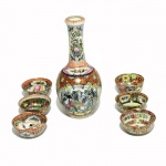 Garrafa de porcelana com seis copos. China, Séc. XX. 16 cm de altura.