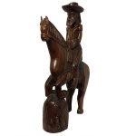 Escultura em jacarandá, representando homem montando cavalo. Assinado L.P.P. 45 x 30 cm.