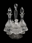 BACCARAT  LINDO GALHETEIRO EM CRISTAL COM RICA LAPIDAÇÃO DOTADO DE CINCO PEÇAS SENDO: DUAS GARRAFAS COM TAMPA, SALEIRO, MOSTARDEIRA E PIMENTEIRO. ACONDICIONADO EM BELISSIMO SUPORTE. FUSTE DO SUPORTE SERRILHADO COM PEGA LAPIDADA EM DIAMANTE. PEÇA MUITO ELEGANTE! FRANÇA, INICIO DO SEC. XX. 28 CM DE ALTURA (uma das tampas tem mínimo bicado)