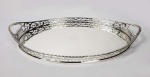 PRATA DE LEI VITORIANA -BELO TABULEIRO EM PRATA DE LEI COM FEITIO OVAL. MARCAS PARA CIDADE DE LONDRES E LETRA DATA PARA 1896. PRATEIRO CHARLES STUART HARRIS ATIVO EM 1871. ELEGANTE E MUITO BONITO! GALERIA FENESTRADA E ALÇAS INCISAS. BORDA COM  PEROLADO, NO PLANO, EM RESERVA, TIMBRE HERÁLDICO COM FIGURA DE ÁGUIA. SOB A BASE DEDICATÓRIA PARA HUGH FAWCUS, CAPITÃO DO REGIMENTO DO DUQUE DE EDIMBURGO. SERVIU NA INDIA NO FINAL DO SEC. XIX (VIDE FOTO DO CAPITÃO SOBRE SEU CAVALO LOGO APÓS A GUERRA ANGLO-ZANZIBARI EM QUE COMANDOU SEU REGIMENTO). A GUERRA ANGLO-ZANZIBARI FICOU CELEBRIZADA POR SER UMA DAS GUERRAS MAIS RÁPIDAS DO MUNDO DURANDO EXATOS 40 MINUTOS. INGLATERRA, 1896, 35 CM DE COMPRIMENTO.NOTA: No século XIX, Zanzibariera um país insular independente noOceano Índico. Hoje o território faz parte da Tanzânia. Os Sultões de Omã tomaram o controle da ilha em 1698 com a expulsão dos portugueses do território, permaneceram então durante muito tempo com o controle nominal do local. Em 1858, o sultão Majid Bin Said declarou a independência de Zanzibari e recebeu o apoio imediato do Reino Unido. Entretanto a iniciativa dividiu o sultanato. O Reino Unido desenvolveu cordiais relações com a ilha após a independência e foi favorecido pela inserção da influência britânica na região. Naquele momento da história, final do século XIX, ocorria uma nova fase de colonialismo dos países ricos no mundo, chamada de imperialismo. Diferentemente do colonialismo do século XVI, neste novo momento o interesse dos países era conquistar zonas de influência e de consumo para seus produtos industrializados. Na ocasião, a Alemanha competia com o Reino Unido pelo controle do comércio e de territórios na África Oriental. Foi a intensificação das disputas entre os países europeus por zonas de controle que gerou a Primeira Grande Guerra Mundial. Zanzibari era governada por sultões com afinidades com os britânicos, no dia 25 de agosto de 1896 o sultão Hamad Bin Thuwaini faleceu subitamente e o processo de sucessão geraria a mais breve guerra da história. Para o lugar do sultão falecido entrou o sultão Khalid Bin Barghash, o qual não era bem visto pelos britânicos. Estes preferiam o sultão Hamud Bin Muhammed, pois era favorável aos interesses britânicos. Além disso, um tratado foi assinado em 1886 determinando que para ascender ao sultanato o candidato escolhido deveria ter a permissão do cônsul britânico, o que não aconteceu com Khalid. Os britânicos ficaram inconformados com a situação e entenderam o ocorrido como motivo para intervenção. O sultão Khalid recebeu um ultimato para abandonar o palácio juntamente com suas tropas, mas em lugar disso montou sua barricada no interior do mesmo. Sem abandonar o local, às 9 horas do dia 27 de agosto de 1896 os britânicos deram a ordem de ataque que iniciou a Guerra Anglo-Zanzibari. Neste momento, os europeus já dispunham de três cruzadores, dois navios de guerra, 150 fuzileiros navais e marinheiros no local. A maior parte da população da ilha ficou ao lado dos britânicos também. O sultão Khalid, por sua vez, reuniu 2800 homens para defender o palácio, entre população civil, guarda nacional, funcionários e escravos. Quando o bombardeio teve início, a artilharia de defesa foi toda neutralizada. A força militar dos britânicos era notoriamente superior e, apenas 40 minutos depois, a bandeira do palácio foi abatida e a guerra chegou ao fim. O resultado da guerra foi a morte de aproximadamente 500 defensores do palácio, sendo que os operadores de armas do sultão foram dizimados. Enquanto isso, apenas um marinheiro britânico sofreu ferimentos graves. O sultão Khalid recebeu asilo no consulado alemão e só veio a ser capturado pelos britânicos em 1916, quando acontecia a Campanha da África Oriental na Primeira Guerra Mundial. Rapidamente o sultão Hamud Bin Muhammed foi colocado pelos britânicos no poder para promover um governo de fantoche. Hamud era fiel aos britânicos e desenvolveu seu governo com ações favoráveis ao interesse dos mesmos, foi o responsável pela extinção da escravidão na ilha. A Guerra Anglo-Zanzibari durou apenas 40 minutos, mas acabou com a soberania do país. Abriu espaço para a forte influência britânica que prevaleceu por mais 67 anos, sem haver mais nenhum tipo de revolta.