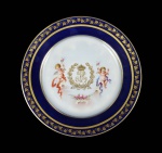 REI LOUIS PHILIPPE - SÉVRES 1846 CHATEAU DES TULLERIES SERVIÇO REAL CONHECIDO COMO SERVIÇO DOS QUERUBINS - BELO PRATO EM PORCELANA DE MANUFATURA SÉVRES, DECORADO COM IMPONENTE MONOGRAMA COROADO EMOLDURADO POR LOUROS COM AS INICIAIS LP DO REI LOUIS PHILIPPE DA FRANÇA. O MONOGRAMA É ALADO POR FIGURAS DE PUCCI. BORDAS COM PARRAS EM OURO SUCEDIDO POR LARGO BARRADO NA TONALIDADE AZUL COBALTO DELIMITADO POR FRISOS DOURADOS. SOB A BASE MONOGRAMA COROADO DO REI, MARCAS DO FABRICANTE SÉVRES E AS INSCRIÇÕES CHATEAU DES TULLERIES (PALÁCIO DAS TULHERIAS). LOUIS PHILIPPE VEIO A SER O AVÔ DO CONDE DEU, PRINCIPE CONSORTE IMPERIAL BRASILEIRO, MARIDO DA PRINCESA ISABEL. FRANÇA, SEC. XIX. 25 CM DE DIAMETRO.