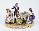 EXCEPCIONAL GRUPO ESCULTÓRICO EM PORCELANA DE GRANDE DIMENSÃO REPRESENTANDO ORQUESTRA FAMILIAR COM CRAVO, FLAUTA E HARPA COM MENINA A DANÇAR. PROFUSAMENTE REMATADA EM OURO. ALEMANHA, INICIO DO SEC. XX. 43 X 31 CM