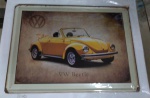 Placa em metal - NEW BEETLE nas dimensões de 40 x 30 centímetros , policromia, cantos arredondados, visível envelhecimento nas extremidades e dobragem / relevo, importada e contemporânea.