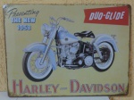 Placa em metal - HARLEY DAVIDSON DUO GLIDE 1958 nas dimensões de 40 x 30 centímetros , policromia, cantos arredondados, visível envelhecimento nas extremidades e dobragem / relevo, importada e contemporânea.