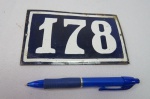Placa esmaltada com o número 178, a qual era fixada nas antigas residências