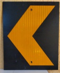 Placa com pintura fluorescente de indicação de curva nas Estradas / Rodovias, usada, possui dois furos centrais nas dimensões de 50 x 60 centímetros.
