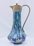 Linda garrafa em vidro iridescente na tonalidade azul, provavelmente Loetz, vidro em perfeito estado com sua tampa original. Tampa necessita de solda. Aprox. 28 cm de altura.