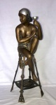 Linda e decorativa estátua representando figura feminina sentada em banco. Bronze. Meados do séc. XX. Lote a seguir faz par. Aprox. 70 cm de altura.