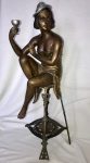 Estátua em bronze representando figura feminina sentada em banco. Bronze meados séc. XX. Necessita restauro e faz par com o lote acima. Aprox. 70 cm.