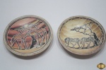Lote com 2 pratos decorativos em cerâmica com paisagem africana. Medindo 15,5cm de diâmetro.