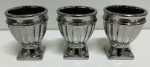 Trio de porcelanas vidrificadas em banho prateado. Medem: 10 cm