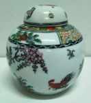 Pote  Chinês com tampa em porcelana no tema floral com galo. Selo de assinatura vermelho no  fundo Mede: 13 cm